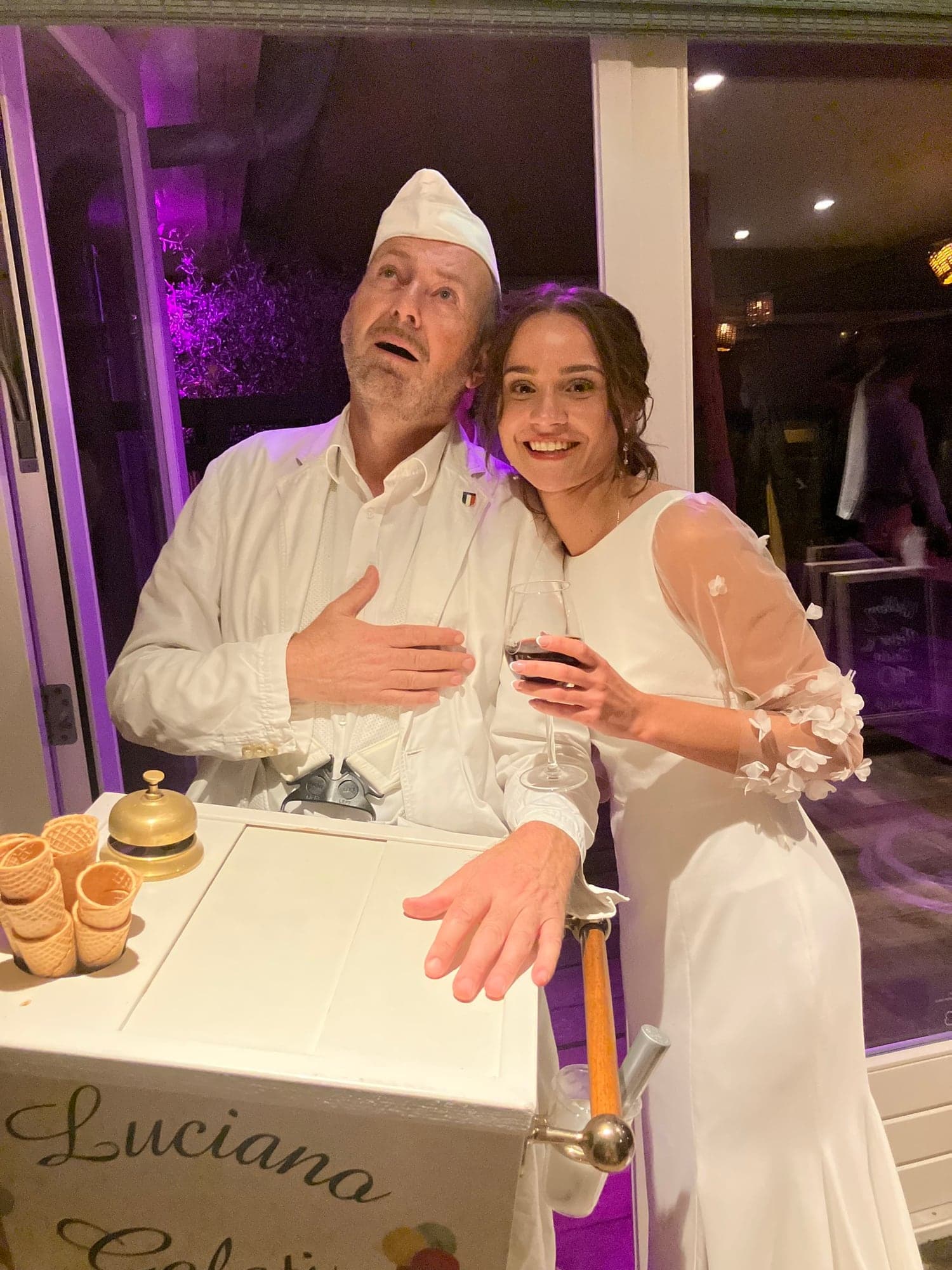 Zingende ijscoman Luciano in wit kostuum zingt op een bruiloft voor de bruid in haar witte trouwjurk